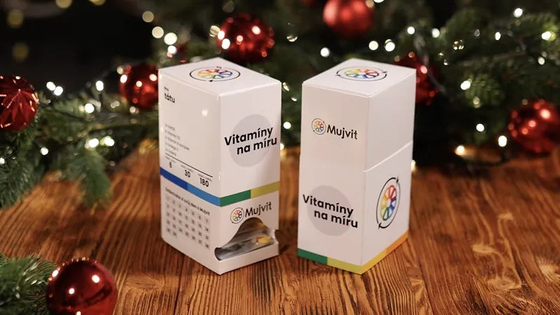 Dvě krabičky Vitamíny na míru Mujvit vedle sebe pod vánočním stromkem