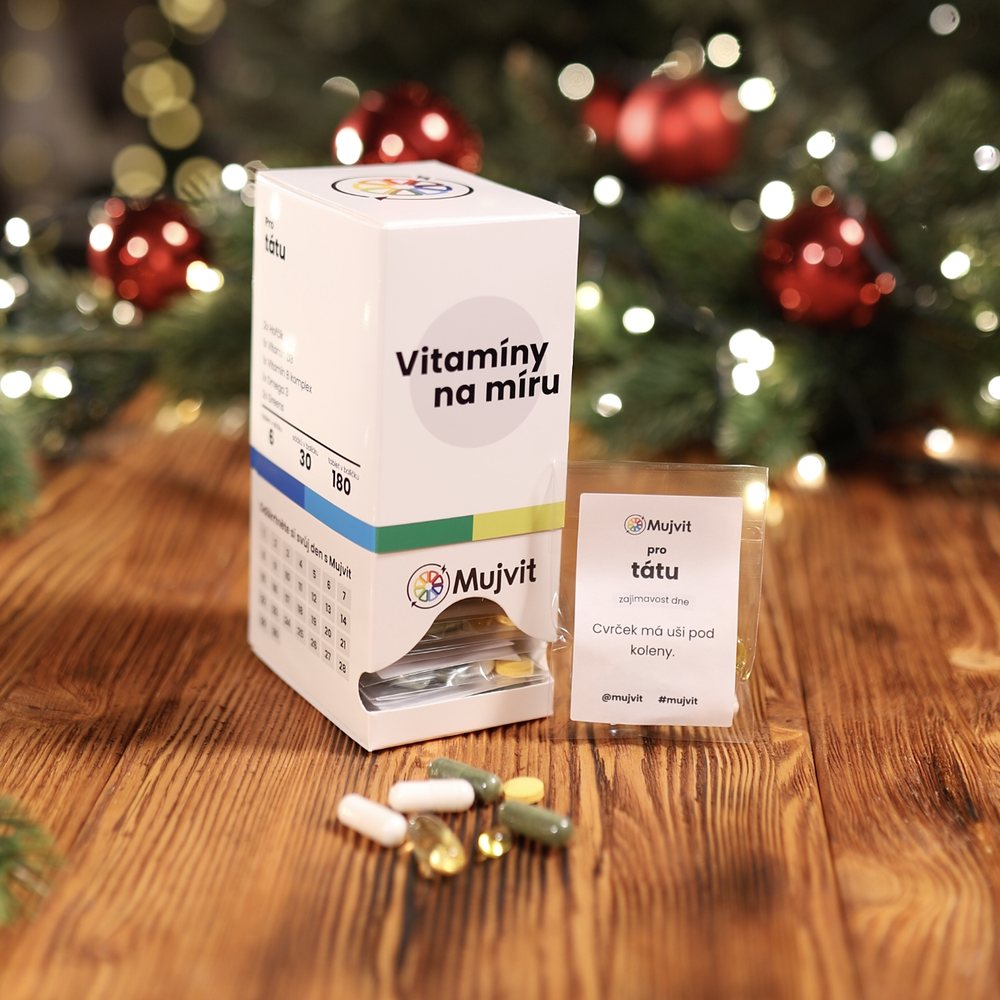 Krabička Vitamíny na míru, denní sáček s oslovením pro tátu a kapsle na dřevěném stole pod vánočním stromkem