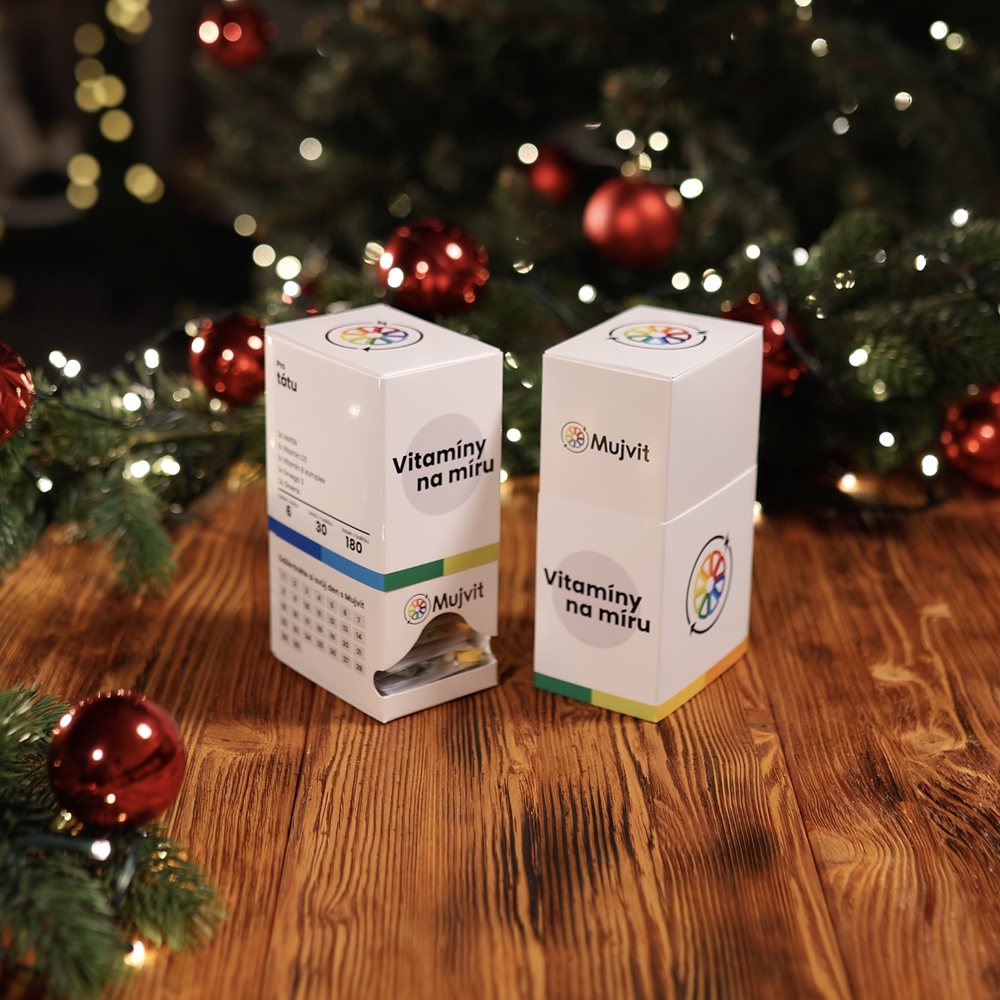 Dvě krabičky Vitamíny na míru Mujvit vedle sebe pod vánočním stromkem